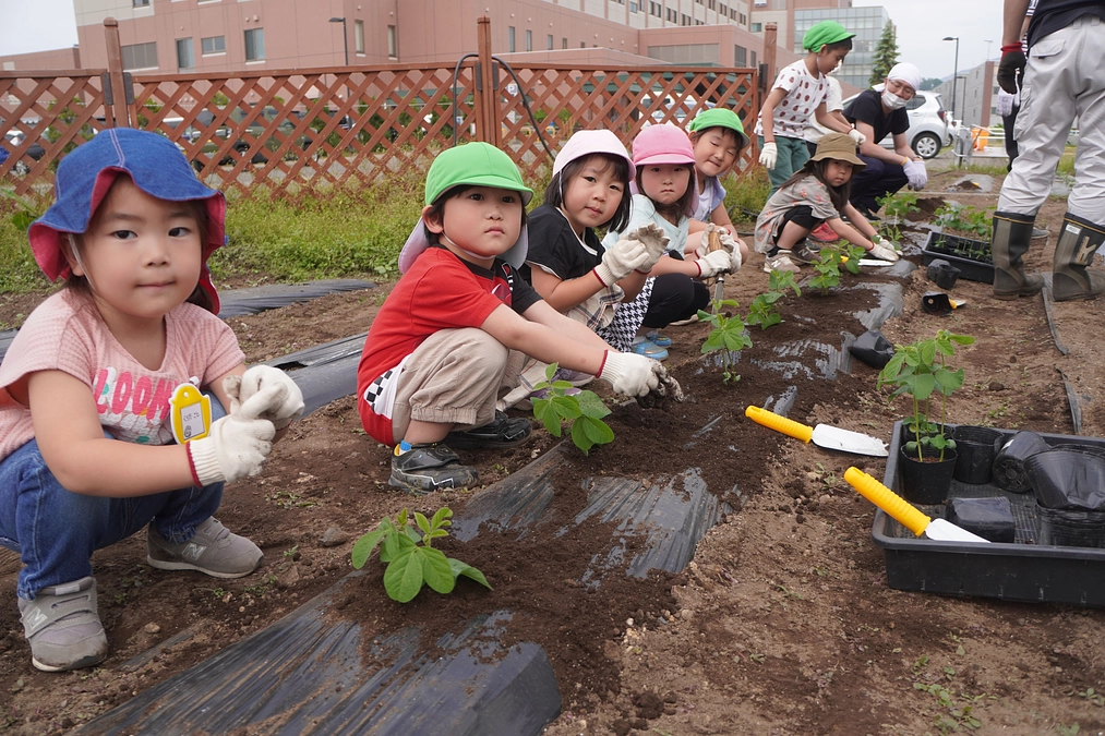 なでしこキッズクラブの子どもたちが、「済生会農園そらしーど」で枝豆の苗植えに挑戦