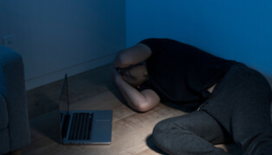 頭を抱えて横たわっている男性