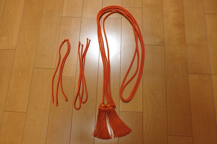 房の付いた橙色の長い紐