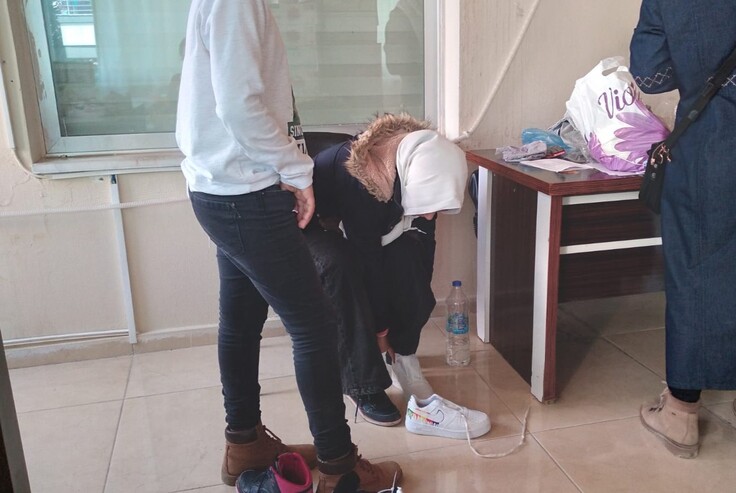 緊急物資の靴のサイズを試す被災者の女性