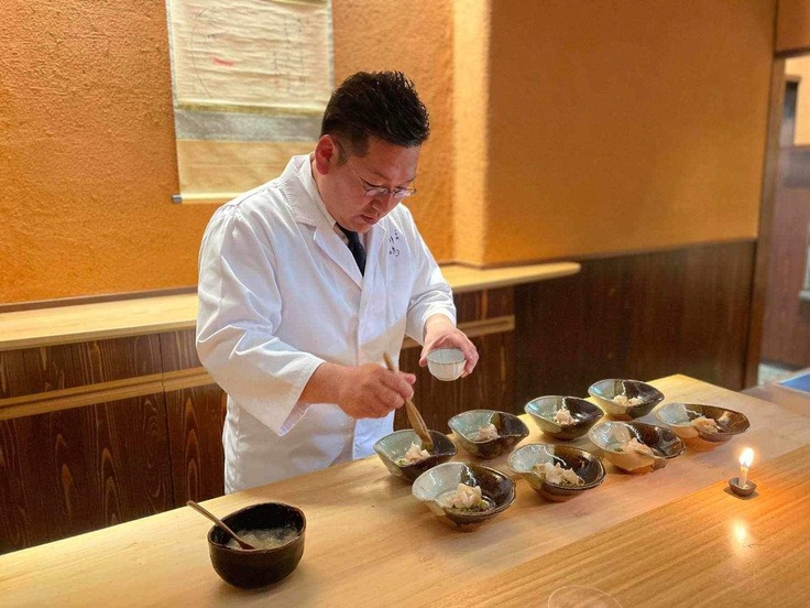 被災前　お客様の前で料理を仕上げる川嶋氏