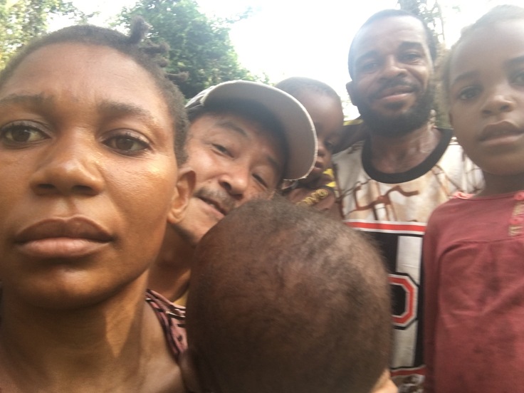 森に依拠するピグミー一家と一緒にいるプロジェクト担当者（中央）©西原智昭