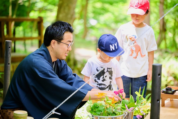 京都の八瀬で開催された『やせのそとあそび2024』で伊住禮次朗理事長が担当した「竹花入に花を入れる」ワークショップの一場面