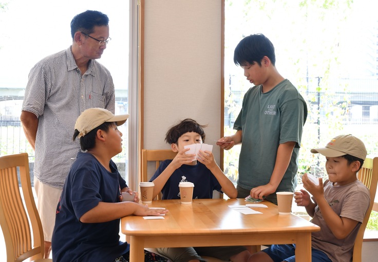 カードゲームで世代を超えてと交流する写真