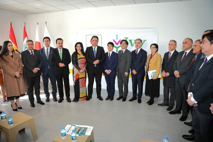 日本の国旗とIVYのロゴの入ったバナーの前に並ぶ来賓