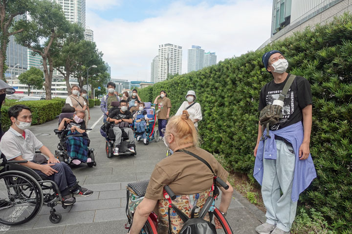 宿泊プログラム参加者がみなとみらいで建物の説明をしている様子