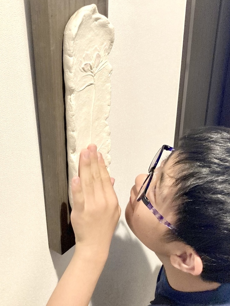 レリーフ作品に触れる男の子