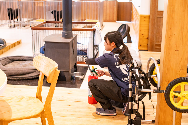 防災訓練で薪ストーブに消火器を向ける職員