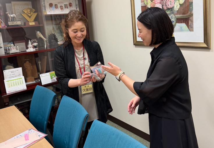 アイガイドフィルムを手に、笑顔でフィルムに感心を寄せる館長と説明する深谷