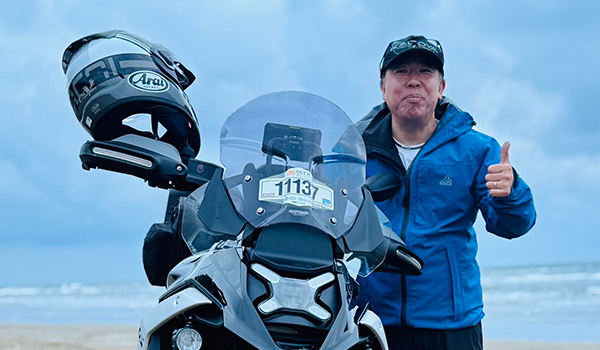 バイクの前に立つ男性