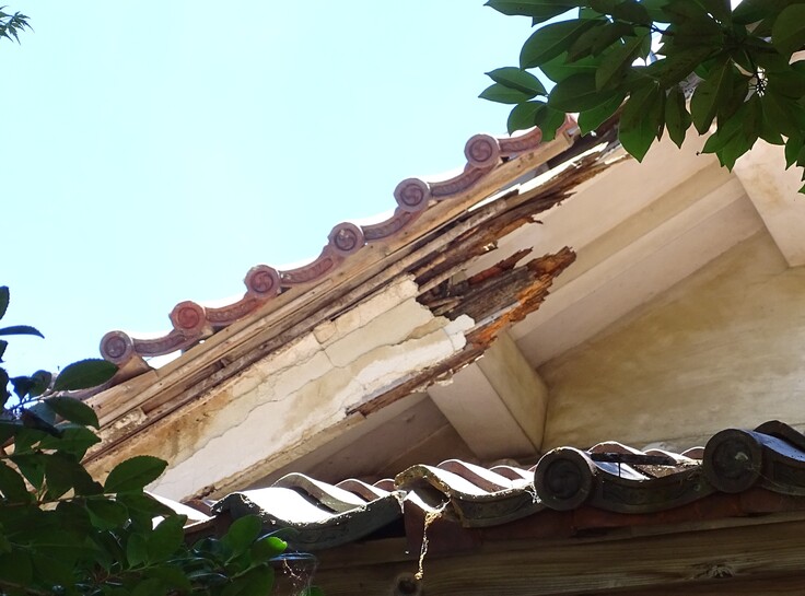 崩れ落ちた庇（ひさし）部分の屋根：すでに木部がむき出しになっています。このままでは風雨による侵食が進み、建物全体に深刻な被害を及ぼすおそらがあります。