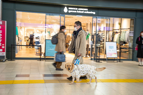 盲導犬と駅ビル内を歩く松井氏