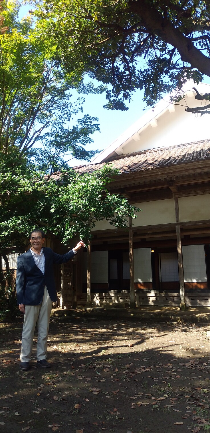 主屋の屋根方向を示すご当主。応急修繕完了後の様子（中庭より）