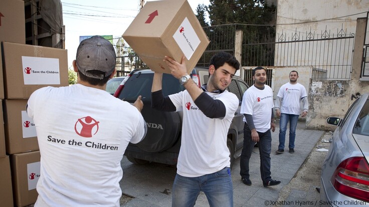 シリア国境付近で生活必需品を配布するセーブ・ザ・チルドレンのスタッフ