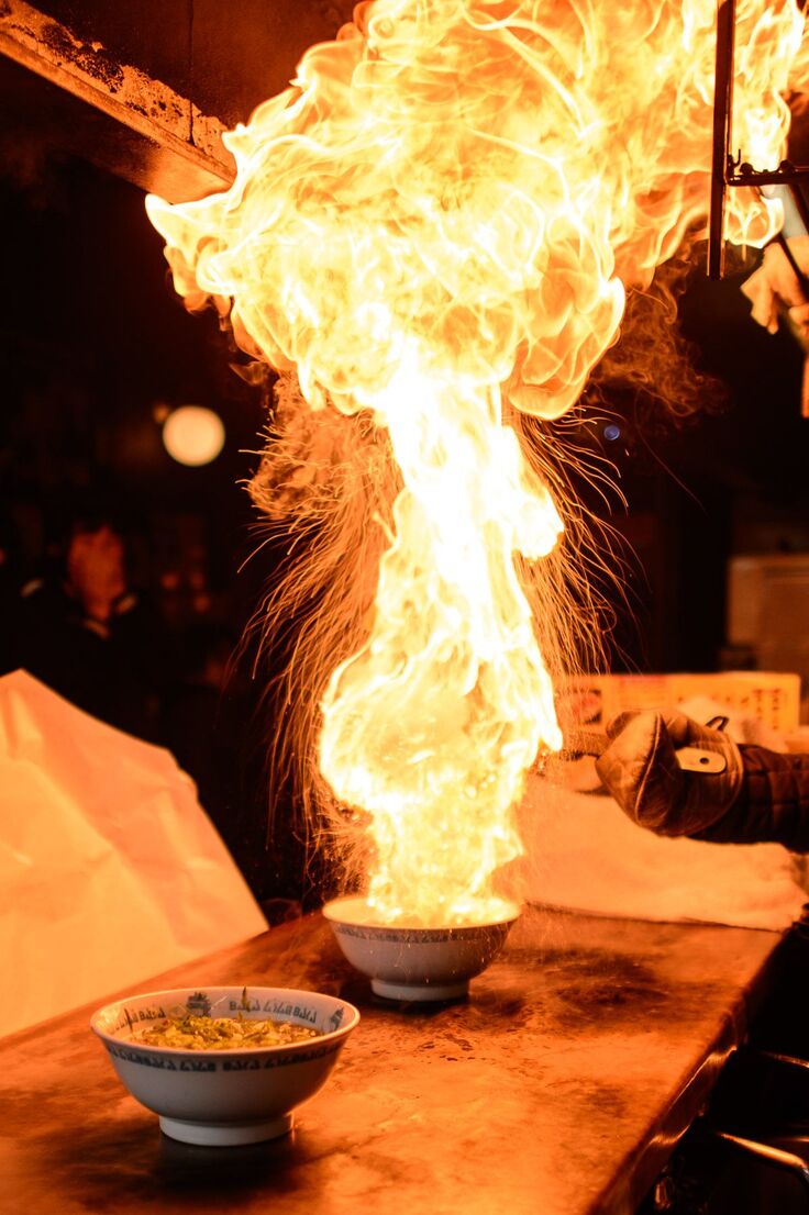 炎が上がるラーメンの様子