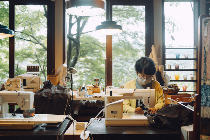 うた種でミシンをする店主