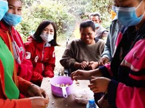 ラオスの現地スタッフや地域の人々と笑顔の藤原早織（中央左）