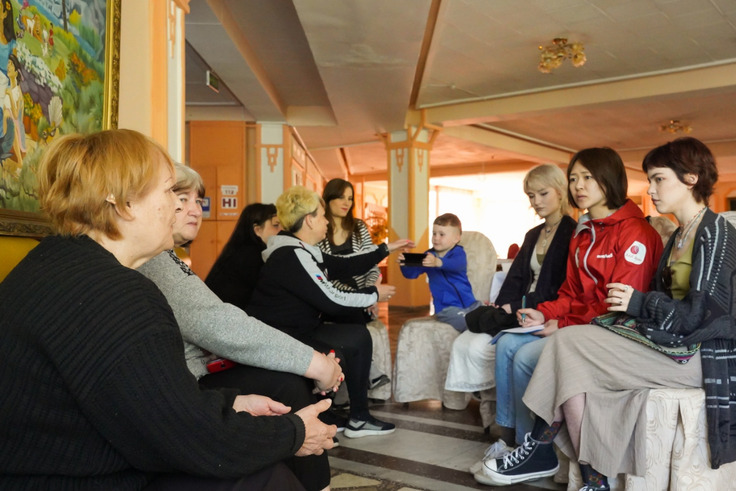車座になったウクライナ難民の女性たちに話を聞くAAR緊急支援チームの藤原早織（右から2番目）